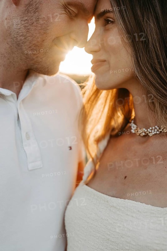 Young couple in love, forehead to forehead in front of the sunset