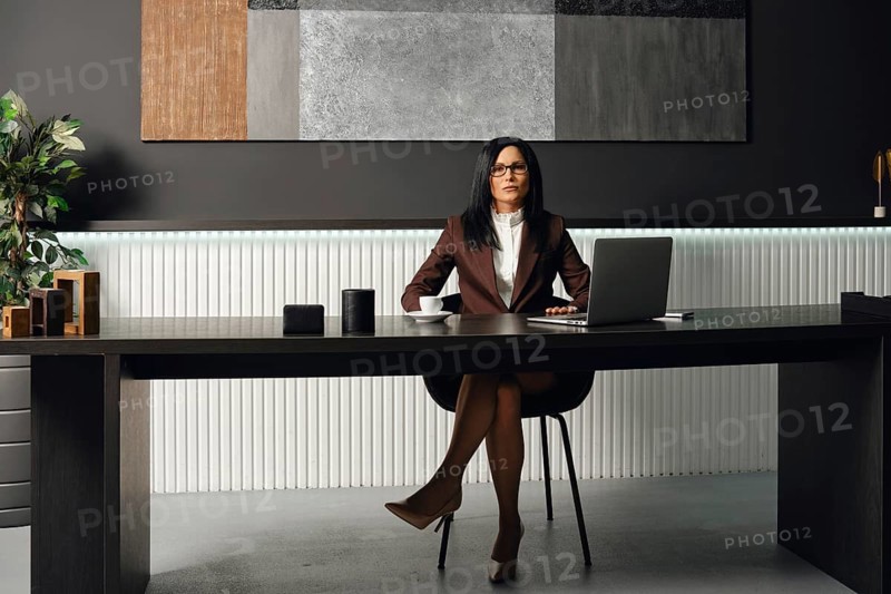 A professional lawyer dressed in formal attire sits at a sleek desk in a contemporary office