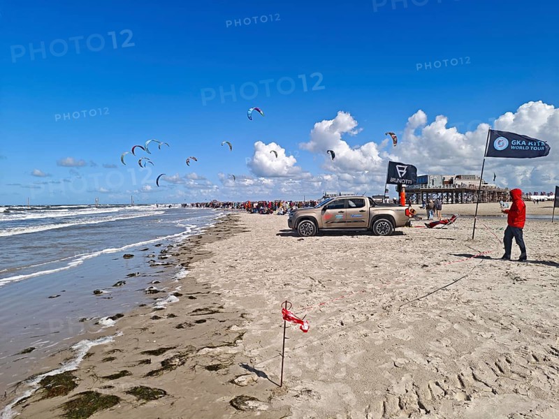 California kitesurfing Masters 2025 on the edge of the Wadden Sea UNESCO World Heritage Site, North Sea, beach, kitesurfing, sport, leisure, spectators, pile dwelling, summer, sun, blue sky, white clouds, Ording, Sankt Peter-Ording, Schleswig-Holstein, Germany