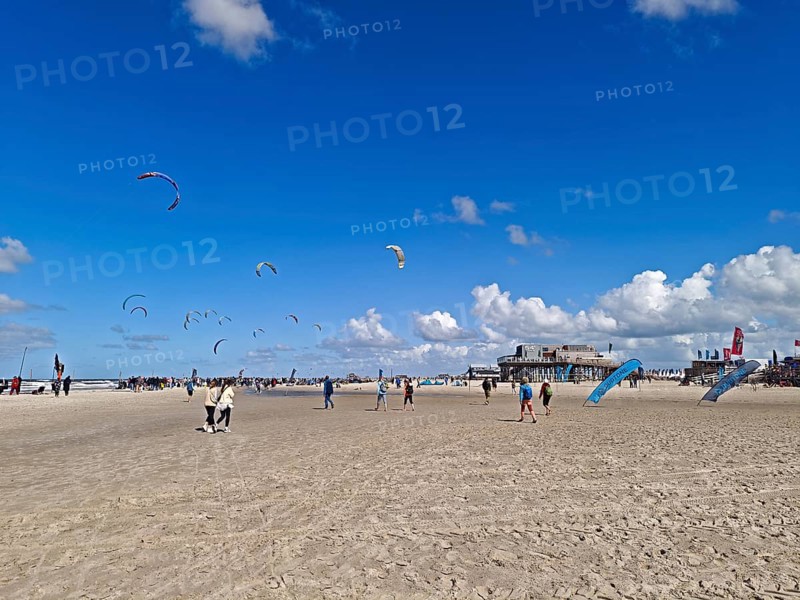 California kitesurfing Masters 2025 on the edge of the Wadden Sea UNESCO World Heritage Site, North Sea, beach, kitesurfing, sport, leisure, pile dwelling, summer, sun, blue sky, white clouds, Ording, Sankt Peter-Ording, Schleswig-Holstein, Germany