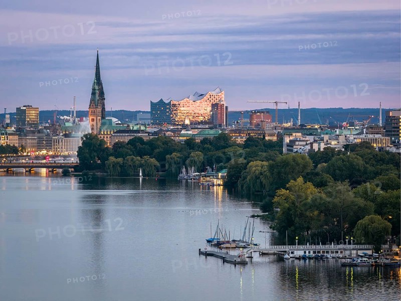 Aerial view of the Outer Alster and Binnenslater at dusk during the Blue Hour with illuminated Elbphilharmonie, City Hall, Alster Fountain, Jungfernstieg, Kennedy Bridge, jetty and churches, Hamburg, Germany