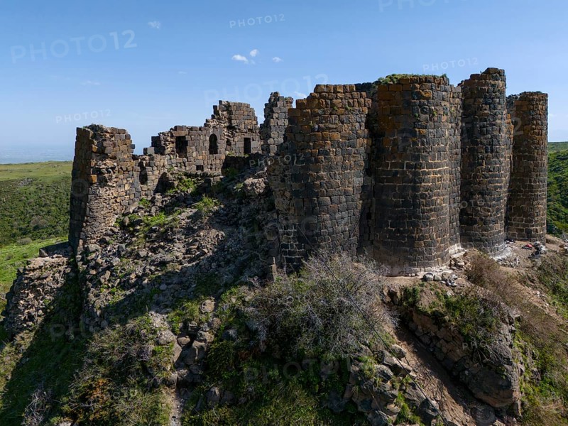 Massive ruins of a stone tower on a hill in nature, aerial view, Amberd Fortress, Aragazotn Province, Armenia