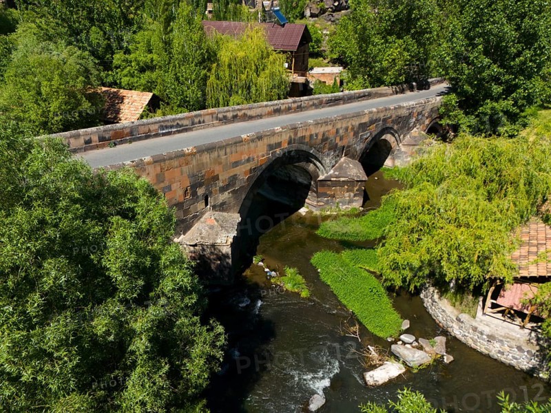 Aerial view of an old stone bridge over a winding river in green nature, aerial view, bridge from 1705 over the Kassagh, Oskahan, Oshakan, Ošakan, Aragazotn Province, Armenia
