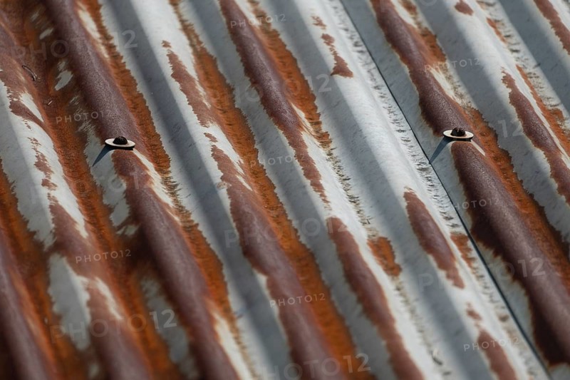 Rusty corrugated metal sheet with weathered texture and visible bolts, Gazipur, Bangladesh