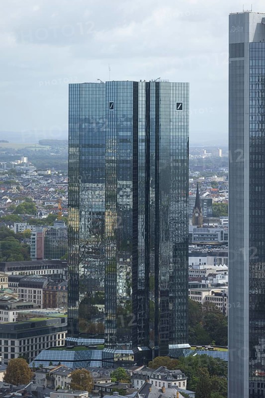 The surroundings of Frankfurt city centre are reflected on the glass façade of the Deutsche Bank Towers, Frankfurt am Main, Hesse, Germany