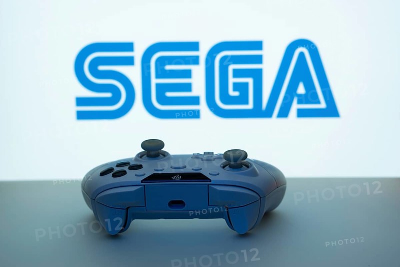 Dhaka, Bangladesh- 13 Sep 2025: A close-up of a white gamepad with the Sega seen on screen in the background