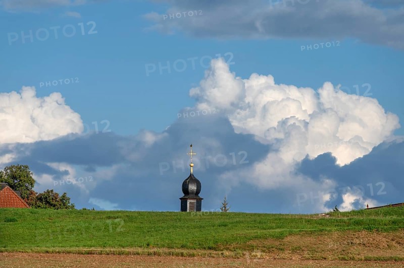 Tower of a chapel behind a meadow hill, cloudy sky, Köttweinsdorf, Upper Franconia, Bavaria, Germany