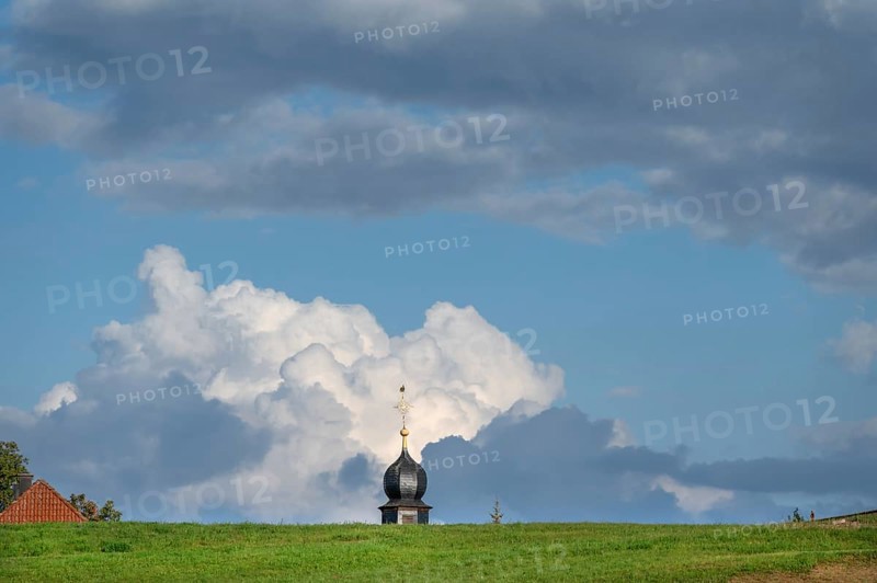 Tower of a chapel behind a meadow hill, cloudy sky, Köttweinsdorf, Upper Franconia, Bavaria, Germany