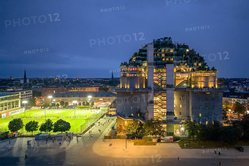 Aerial view of the Hamburg bunker on Heiligengeistfeld during the blue hour with illuminated floors and green trees at night, Hamburg, Germany