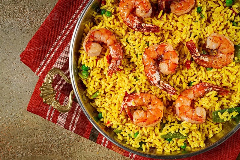 Rice with saffron and shrimp, in a frying pan, paella with shrimp, top view, homemade, no people