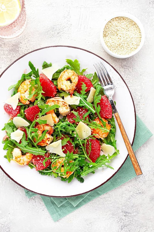 Fresh shrimp salad with arugula, grapefruit, and parmesan served in a bowl
