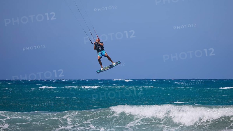 Kitesurfer jumping high over waves under a clear blue sky, Prasonisi, beach, surf, windsurfer, kite surfer, waves, south coast, Rhodes, Dodecanese, Greek Islands, Greece