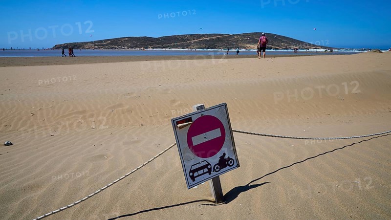 Prohibition sign stands in the sand of a wide beach under a blue sky, Prasonisi, beach, surf, windsurfer, kite surfer, waves, south coast, Rhodes, Dodecanese, Greek Islands, Greece