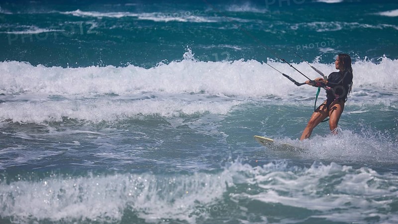Kitesurfer gliding through moving waves in the ocean under blue sky, Prasonisi, beach, surf, windsurfer, kite surfer, waves, south coast, Rhodes, Dodecanese, Greek Islands, Greece