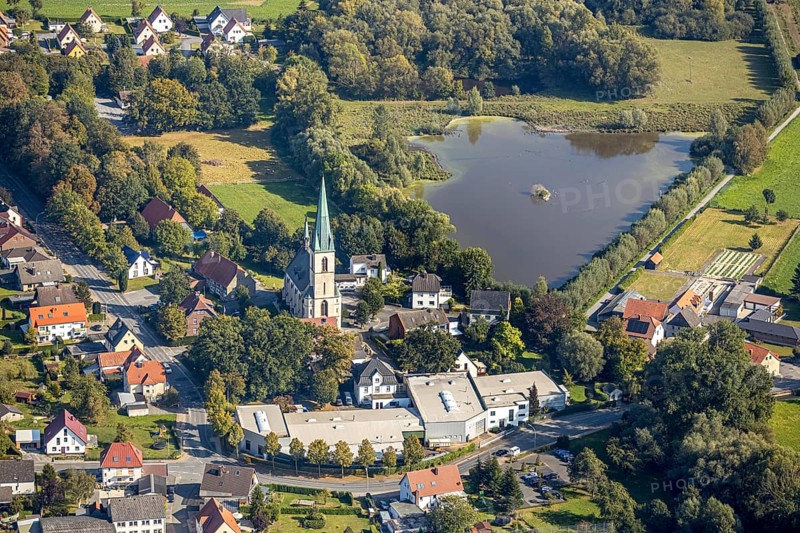 Aerial view, St Christophorus parish church, Wöstegraben pond, F. Schumacher Maschinenbauunternehmen, Ostinghausen, Bad Sassendorf, Kreis Soest, North Rhine-Westphalia, Germany, place of worship, DE, Europe, commercial enterprises, commercial area, commercial location, commercial use, religious community, place of worship, industrial area, industrial location, church, parish, Kirchstraße, denomination, Kreis-Soest-Buch, KreisSoestBuch, landscape conservation area Woeste, aerial photograph, aerial photography, aerial photography, religion, pond, overview, bird's-eye view, birds-eyes view, overview