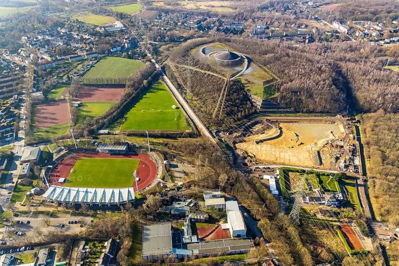Aerial photograph, Lohrheide stadium, Rheinelbe spoil tip, construction site rainwater retention basin Wattenscheider Bach, Leithe, Bochum, Ruhr area, North Rhine-Westphalia, Germany, construction work, construction area, construction project, mining, spoil tip, DE, Europe, football pitch, football stadium, football club, Gelsenkirchen, spoil tip, landmark, landscape forms, landscape park, Leithestraße, Lohrheide, aerial view, aerial photography, aerial photography, Olympic training centre Ruhr-Ost, route industrial heritage, pointed cone, sports, sports facilities, sports field, sports field Espenloh, sports facility, stadium, table mountain, overview, bird's-eye view, birds-eyes view, former Rheinelbe colliery, overview