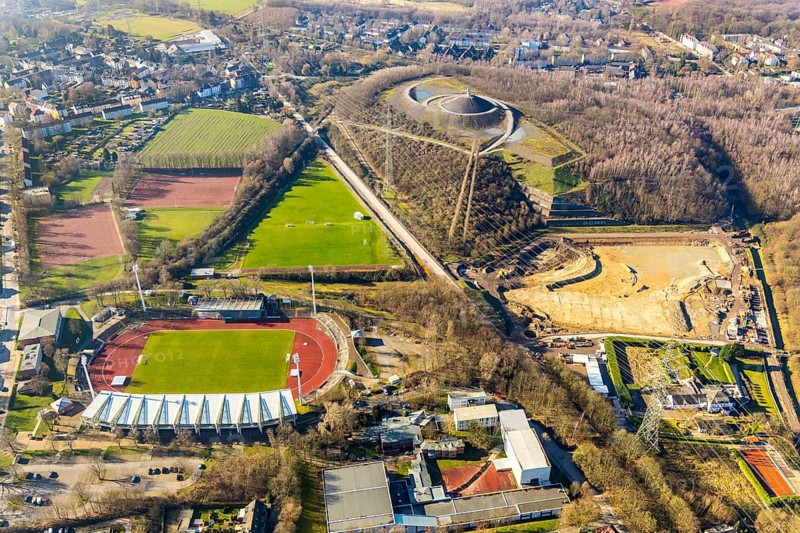 Aerial photograph, Lohrheide stadium, Rheinelbe spoil tip, construction site rainwater retention basin Wattenscheider Bach, Leithe, Bochum, Ruhr area, North Rhine-Westphalia, Germany, construction work, construction area, construction project, mining, spoil tip, DE, Europe, football pitch, football stadium, football club, Gelsenkirchen, spoil tip, landmark, landscape forms, landscape park, Leithestraße, Lohrheide, aerial view, aerial photography, aerial photography, Olympic training centre Ruhr-Ost, route industrial heritage, pointed cone, sports, sports facilities, sports field, sports field Espenloh, sports facility, stadium, table mountain, overview, bird's-eye view, birds-eyes view, former Rheinelbe colliery, overview