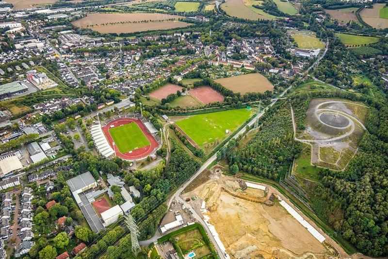 Aerial view, Lohrheide stadium, Rheinelbe slag heap, Wattenscheider Bach rainwater retention basin construction site, former Rhenish railway road, RS1 cycle highway, Leithe, Bochum, Ruhr area, North Rhine-Westphalia, Germany, railway line, construction work, construction area, construction measure, construction project, mining, slag heap, Bochum-Wattenscheid, DE, Europe, football pitch, football stadium, football club, Gelsenkirchen, slag heap, Himmelstreppe, Hollandstraße, landmark, landscape forms, landscape park, Leithestraße, Lohrheide, aerial view, aerial photography, aerial photography, Olympic training centre Ruhr-Ost, RS1, Route of Industrial Heritage, pointed cone, sport, sports facilities, sports field, sports field Espenloh, sports facility, stadium, Wattenscheid district, Tafelberg, Rheinische Bahn road, overview, bird's-eye view, Wattenscheid, birds-eyes view, former railway line, former Rheinelbe colliery, overview