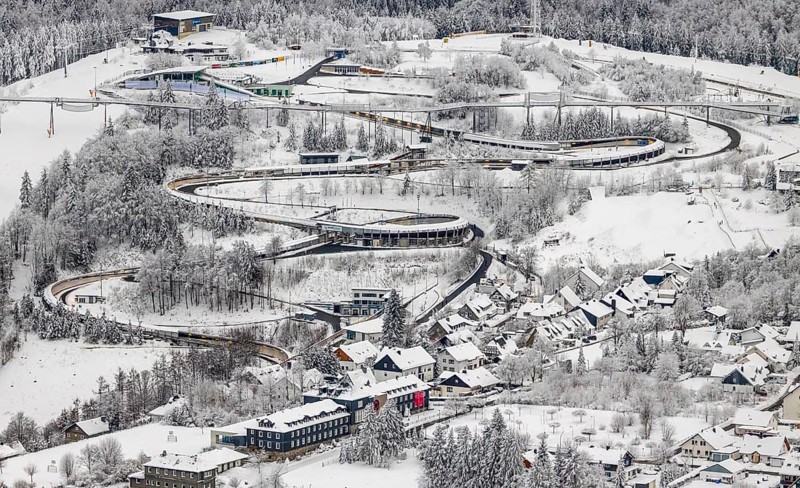 Aerial view of the snowy winter landscape of Winterberg with the VELTINS-EisArena Winterberg bobsleigh run in Sauerland in North Rhine-Westphalia, Germany, Sauerland, Europe, aerial photo, birds-eyes view, aerial photography, aerial photography, overview, bird's eye view, lockdown, closed winter landscape, corona lockdown, deserted, snow, winter weather, corona-related lockdown