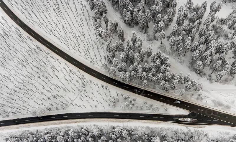 Aerial view of the snowy winter landscape of Winterberg with winding roads and paths with a V-shaped fork in the road in Sauerland in North Rhine-Westphalia, Germany, Sauerland, Europe, aerial photo, birds-eyes view, aerial photography, aerial photography, overview, bird's eye view, lockdown, closed winter landscape, corona lockdown, deserted, snow, winter weather, corona-related lockdown