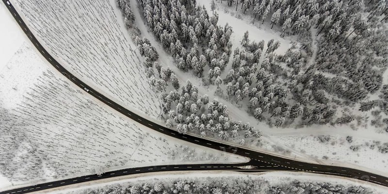 Aerial view of the snowy winter landscape of Winterberg with winding roads and paths with a V-shaped fork in the road in Sauerland in North Rhine-Westphalia, Germany, Sauerland, Europe, aerial photo, birds-eyes view, aerial photography, aerial photography, overview, bird's eye view, lockdown, closed winter landscape, corona lockdown, deserted, snow, winter weather, corona-related lockdown