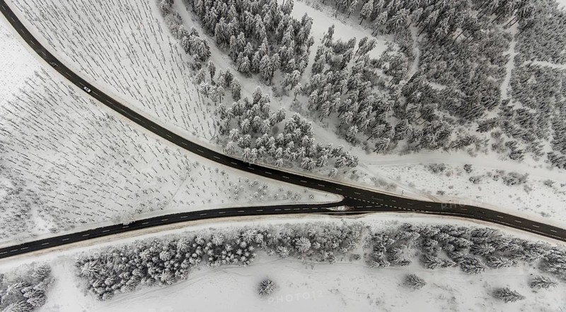 Aerial view of the snowy winter landscape of Winterberg with winding roads and paths with a V-shaped fork in the road in Sauerland in North Rhine-Westphalia, Germany, Sauerland, Europe, aerial photo, birds-eyes view, aerial photography, aerial photography, overview, bird's eye view, lockdown, closed winter landscape, corona lockdown, deserted, snow, winter weather, corona-related lockdown