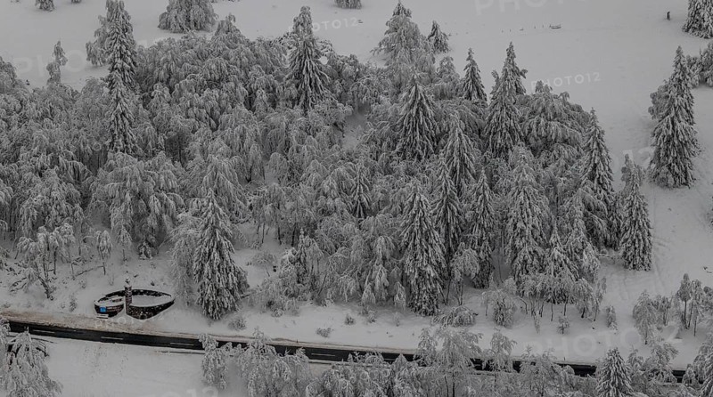 Aerial view of the snowy winter landscape of Winterberg below the Kahler Asten with snow-covered trees and firs in the Sauerland in North Rhine-Westphalia, Germany, Sauerland, Europe, aerial photo, birds-eyes view, aerial photography, aerial photography, overview, bird's eye view, lockdown, closed winter landscape, corona lockdown, deserted, snow, winter weather, corona-related lockdown, high heath in winter