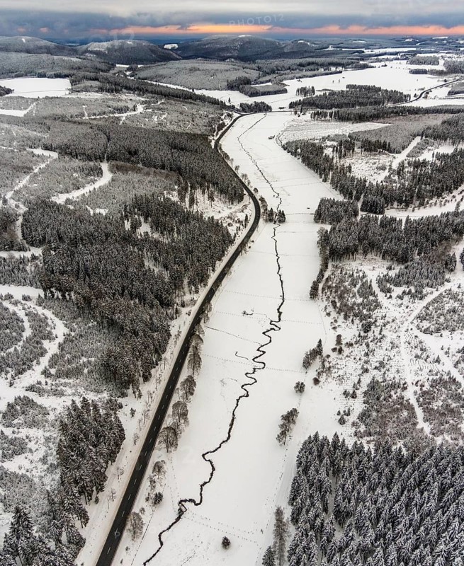 Aerial view of the Ruhr valley with the meandering Ruhr as a stream in the snowy winter landscape of Winterberg in Sauerland in North Rhine-Westphalia, Germany, Sauerland, Europe, aerial view, birds-eyes view, aerial photography, aerial photography, overview, bird's eye view, lockdown, closed winter landscape, corona lockdown, deserted, snow, winter weather, corona-related lockdown
