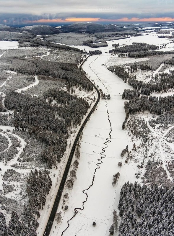 Aerial view of the Ruhr valley with the meandering Ruhr as a stream in the snowy winter landscape of Winterberg in Sauerland in North Rhine-Westphalia, Germany, Sauerland, Europe, aerial view, birds-eyes view, aerial photography, aerial photography, overview, bird's eye view, lockdown, closed winter landscape, corona lockdown, deserted, snow, winter weather, corona-related lockdown