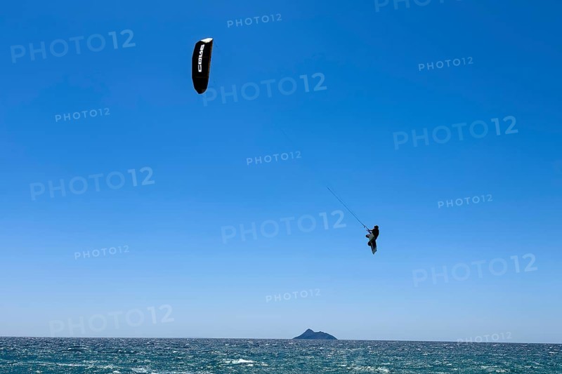 Kitesurfer kite surfer makes big high giant jump with kite kite sail over sea surface, international
