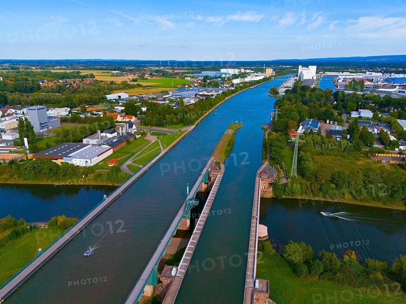 A panoramic view shows a canal with bridges and surrounding city and industrial buildings as well as green areas, waterway junction, Mittellandkanal over Weser, trough bridge, Minden, North Rhine-Westphalia, Germany