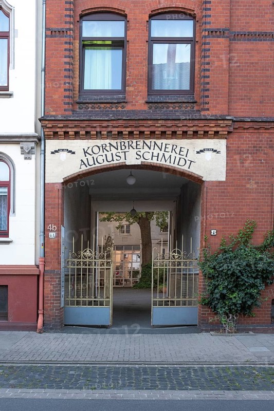 Photograph of the entrance to an old grain distillery with a wrought-iron golden Tor tor, Hainholz, Hanover, Lower Saxony, Germany