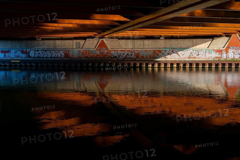 View across the Mittelland Canal to the underside and the graffiti-painted abutment of a bridge on the B6, Hanover, Lower Saxony, Germany