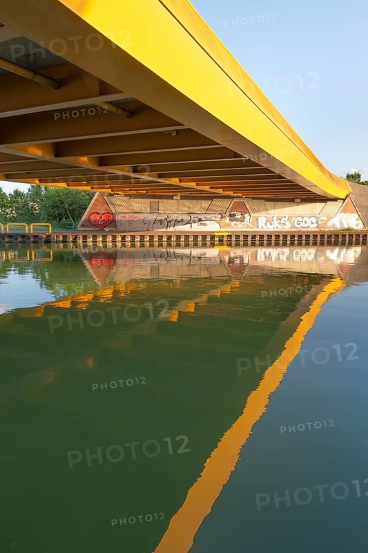 View across the Mittelland Canal to the underside and the graffiti-painted abutment of a bridge on the B6, Hanover, Lower Saxony, Germany