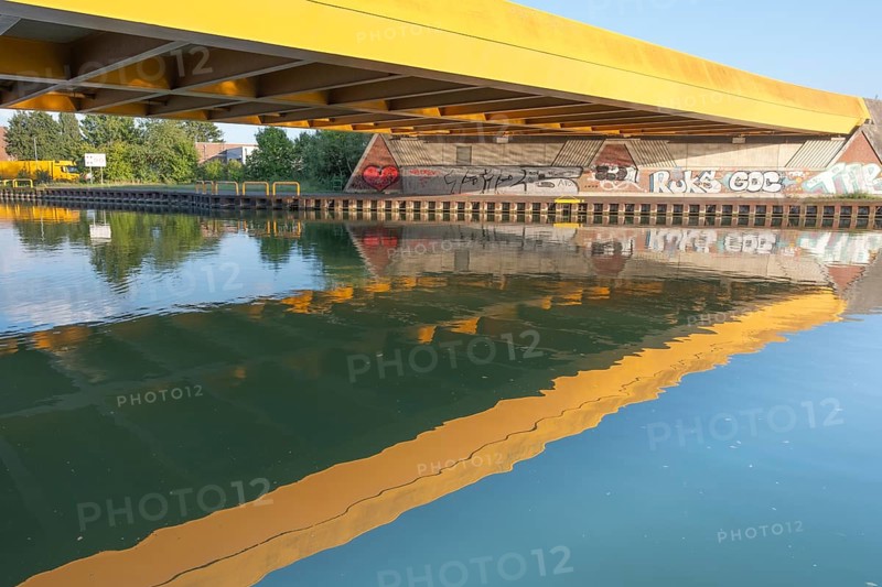View across the Mittelland Canal to the underside and the graffiti-painted abutment of a bridge on the B6, Hanover, Lower Saxony, Germany