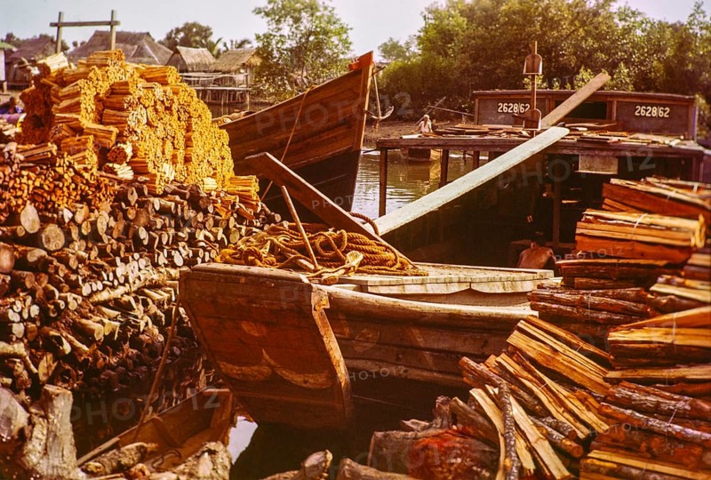 Loading wood timber products onto barge boat in timber yard, Johor Bahru, Johor, Malaya, Malaysia, south east Asia 1963