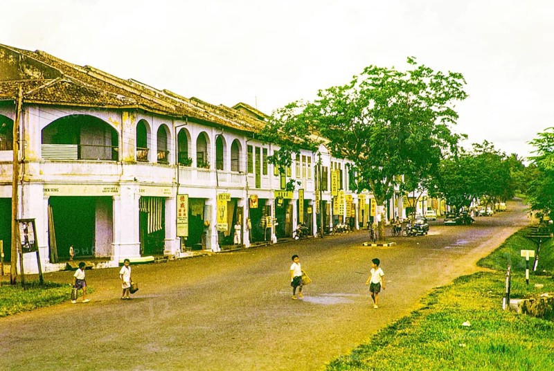 Row of Chinese shophouses businesses in building, unspecified location in Malaya, Malaysia, south east Asia 1963 - closest business is Tuck Seng dentist and watch maker