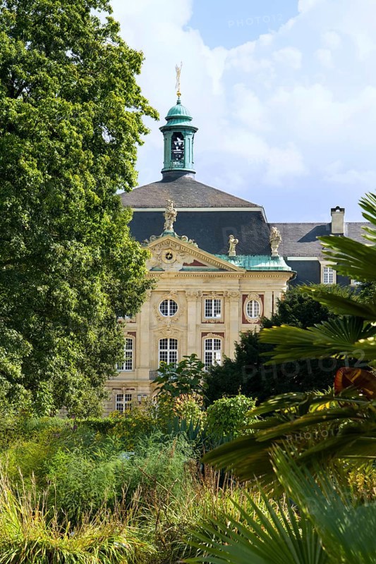 View from the exotical jungle of the botanical garden to the Prince Bishop's Castle, Fürstbischöflichen Schloss, Münster, North Rhine-Westphalia, Germany