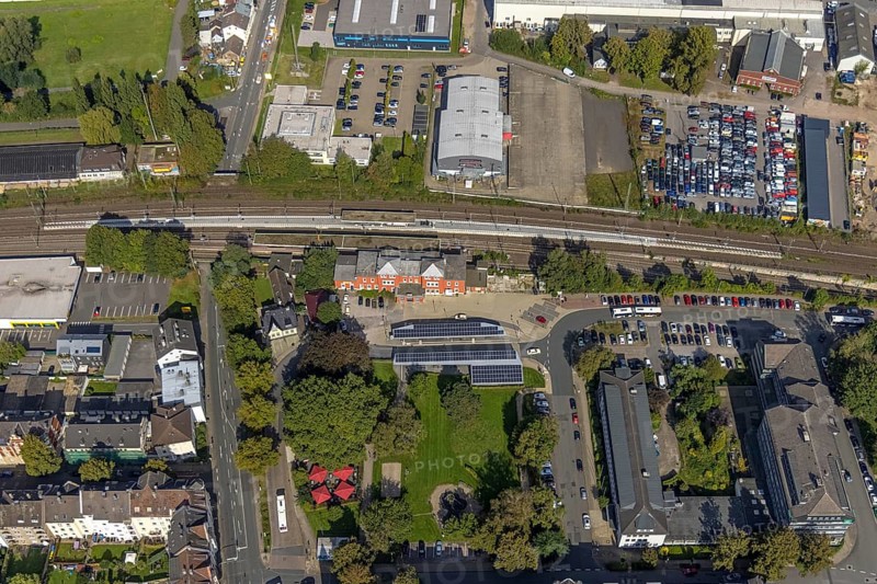 Aerial view, Schwelm railway station with red station building and bus station with solar roof and YNS Arena Eventhalle Schwelm in Schwelm, Ruhr area, North Rhine-Westphalia, Germany, railway station, station forecourt, bus station, DE, Deutsche Bahn AG, Europe, central station, main station, culture, art, aerial view, aerial photography, aerial photography, Schwelm, overview, event location, event venue, bird's-eye view, ZOB, birds-eyes view, cultural use, overview