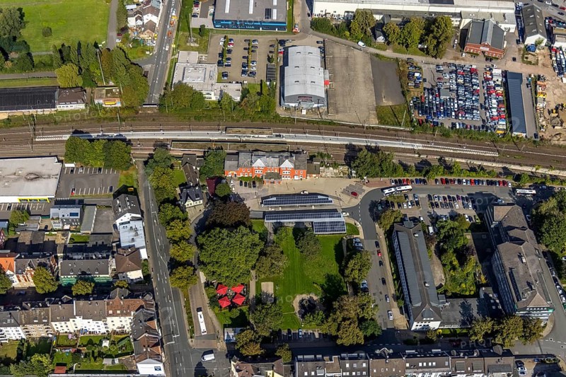 Aerial view, Schwelm railway station with red station building and bus station with solar roof and YNS Arena Eventhalle Schwelm in Schwelm, Ruhr area, North Rhine-Westphalia, Germany, railway station, station forecourt, bus station, DE, Deutsche Bahn AG, Europe, central station, main station, culture, art, aerial view, aerial photography, aerial photography, Schwelm, overview, event location, event venue, bird's-eye view, ZOB, birds-eyes view, cultural use, overview