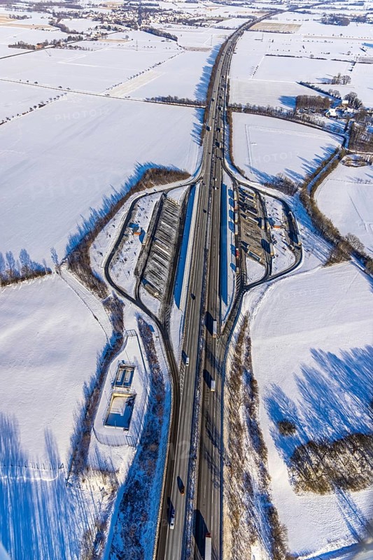 Aerial photo, Ostönner Grund rest area on the A44 motorway, snow, winter, rest areas, trucks, Röllingsen, Soest, Soester Börde, North Rhine-Westphalia, Germany, Soester, Börde, DE, Europe, birds-eyes, view, aerial photography, aerial photography, overview, overview, bird's eye view, winter weather, onset of winter, cold, rest area, Ostönner, Grund, transport, traffic, infrastructure, logistics, road traffic, parking, cars, parking area