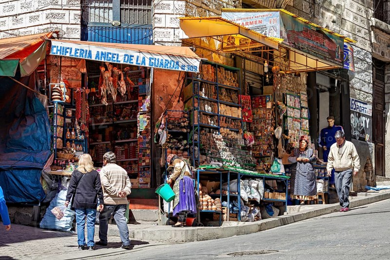A busy market stall with souvenirs on a street corner surrounded by people, The witches' market of La Paz in Bolivia