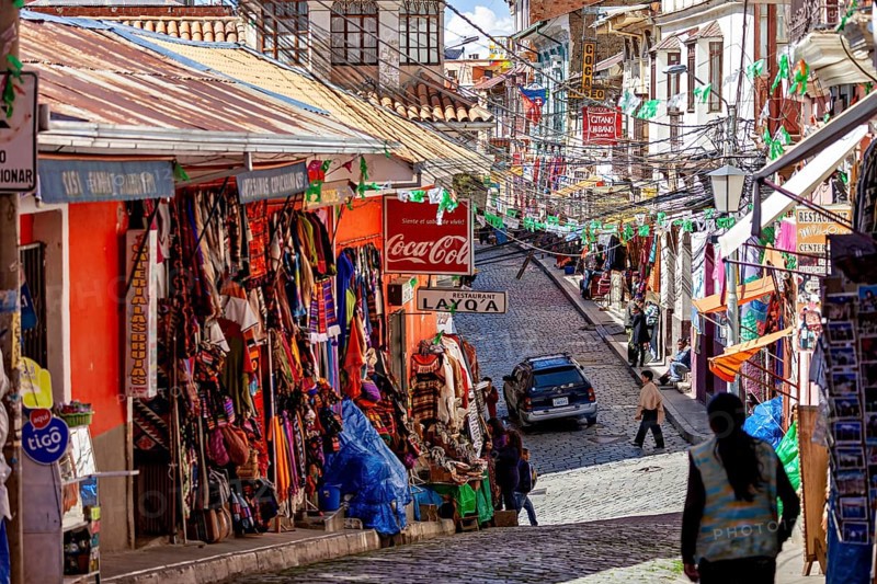 A lively street with colourful shops and people in a mountainous setting, the witches' market in La Paz, Bolivia
