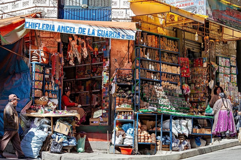 A street scene with a stall full of colourful goods and people in traditional dress, the witches' market in La Paz, Bolivia