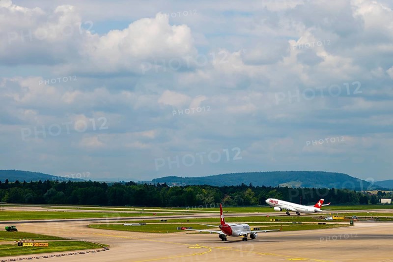 Swiss Airlines Passenger Airplane Take Off From the Runway and Flying Against Blue Sky and Clouds in a Sunny Summer Day From the Airport in Kloten, Zurich, Zurich Canton, Switzerland
