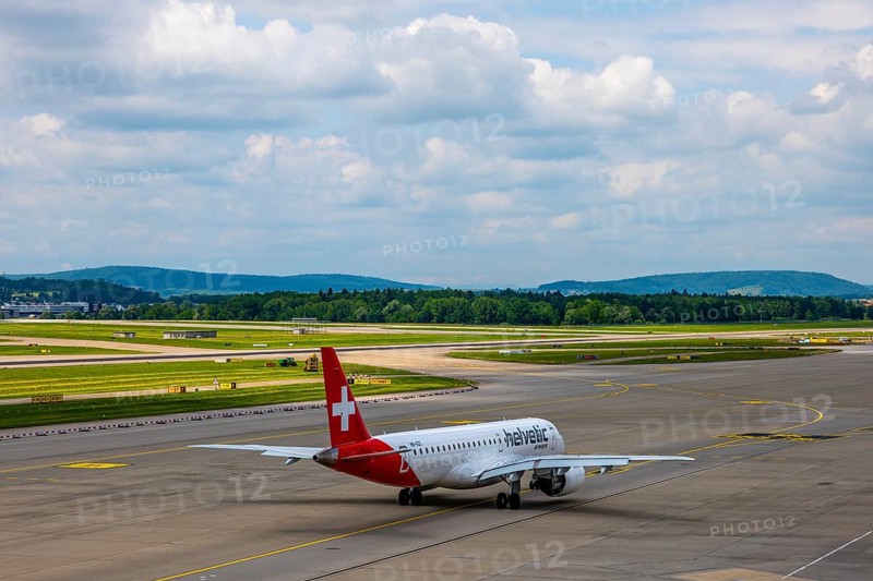 Helvetic Airways Passenger Airplane Taxiing on Runway in a Sunny Summer Day From the Airport in Kloten, Zurich, Zurich Canton, Switzerland
