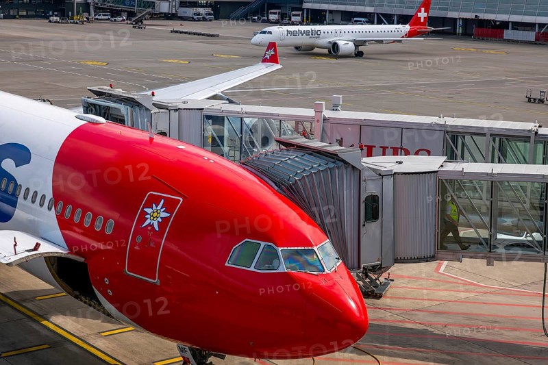 Zurich Airport and Passenger Airplane and Boarding Bridge Gate on Airfield in a Sunny Summer Day From the Airport in Kloten, Zurich, Zurich Canton, Switzerland