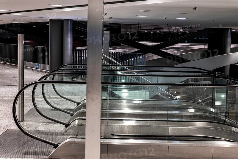 Inside Illuminated Zurich Airport with Escalator at Night in the Airport in Kloten, Zurich, Zurich Canton, Switzerland