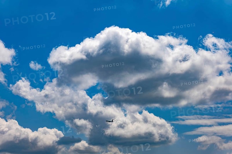 Passenger Airplane Flying Against Blue Sky and Clouds in a Sunny Summer Day From the Airport in Kloten, Zurich, Zurich Canton, Switzerland