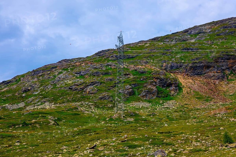 Electricity Pylon with Mountain View in the Swiss Alps in a Sunny Summer Day in Bernina, Valposchiavo, Pontresina, Grisons, Switzerland
